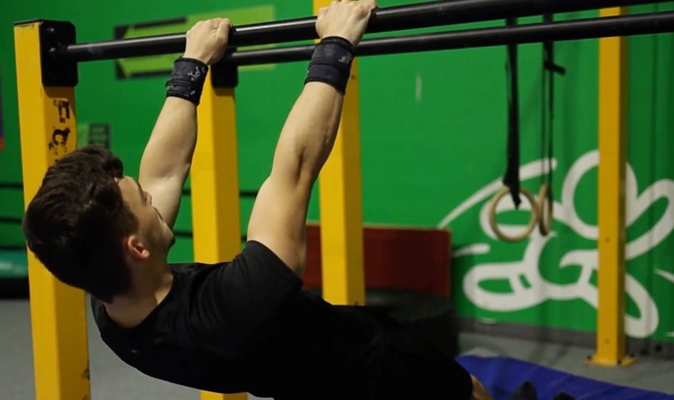 Karol robiący front lever na drążku z nogami na ziemi