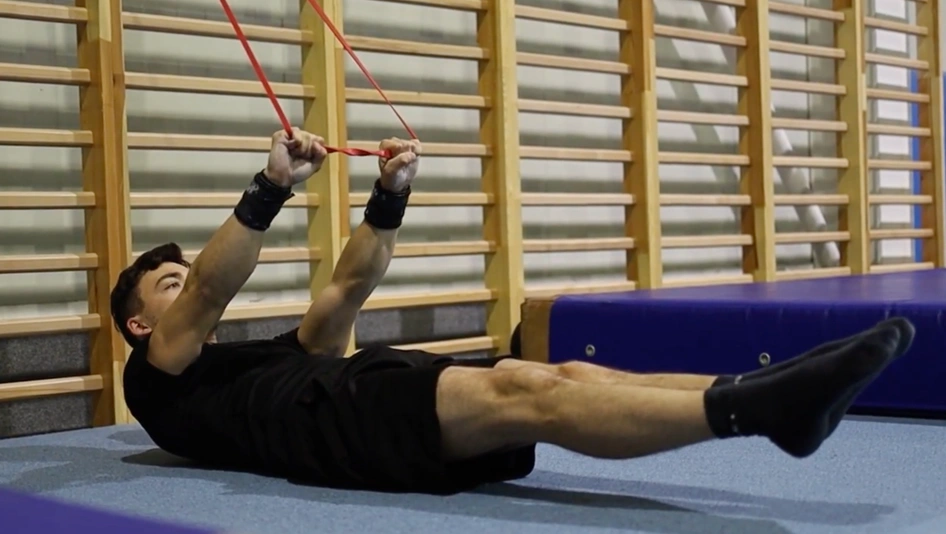 Karol robiący hollow body z gumą